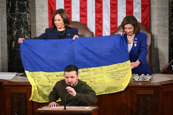 Ukraine's President Volodymyr Zelensky speaks after giving a Ukrainian national flag to US House Speaker Nancy Pelosi (D-CA) and US Vice President Kamala Harris (L) during his address the US Congress at the US Capitol in Washington, DC on December 21, 2022.